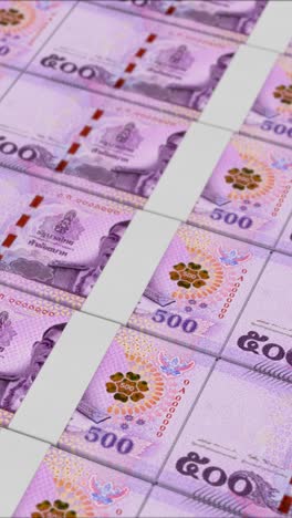 vertical video of 500 thai baht banknotes printed by a money press