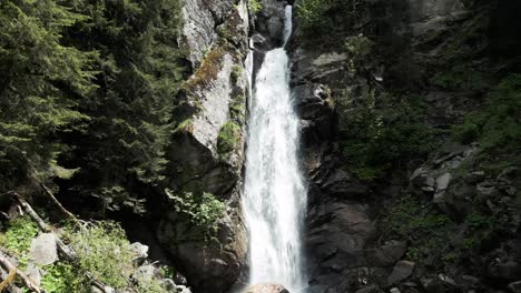 drone shot approaching and rising up the cascade du dard waterfall in france