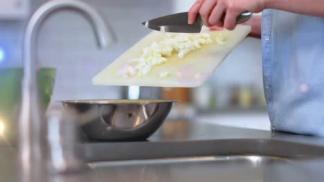 Animation-of-light-over-midsection-of-man-cooking-using-knife-and-chopping-board-in-kitchen