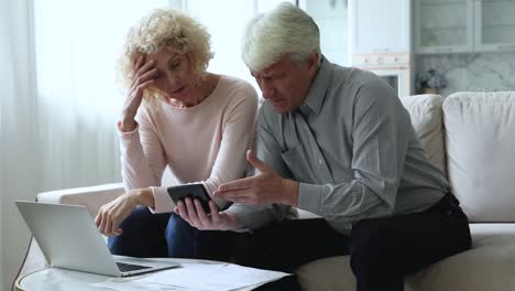 retired couple calculate bills, experiencing financial difficulties, feel stressed