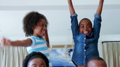 Kids-and-parents-cheering-while-watching-match-on-television-in-living-room