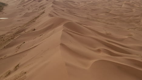 backward aerial view of goby desert sand dunes, mongolia