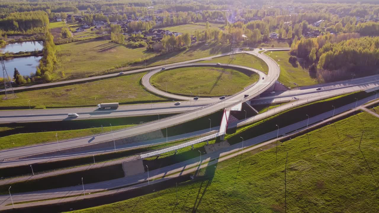 Aerial bird’s-eye shot of highway and roundabout under bright sunshine