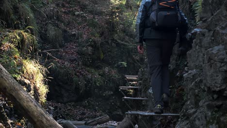excursionista camina por las escaleras de hierro en el par nacional del paraíso eslovaco