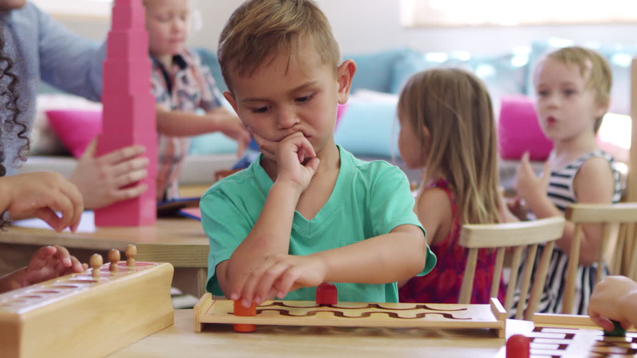 alumno de montessori trabajando en un escritorio con un rompecabezas de forma de madera