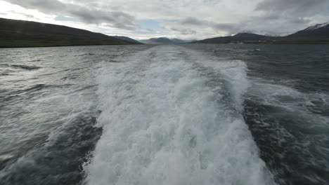 foam from behind a boat in iceland. cloudy day slow motion