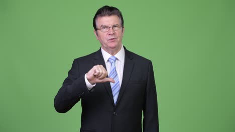 Sad senior handsome businessman giving thumbs down