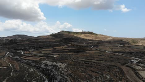 malta, gozo island gorge canyon and farmland towards the mountain and village of għasri