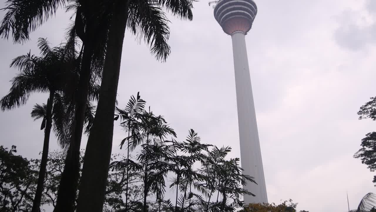 view of KL Tower amidst silhouettes of palm trees in Kuala Lumpur, Malaysia