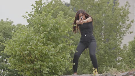 Wide-view-of-Attractive-woman-aiming-a-pistol-towards-camera