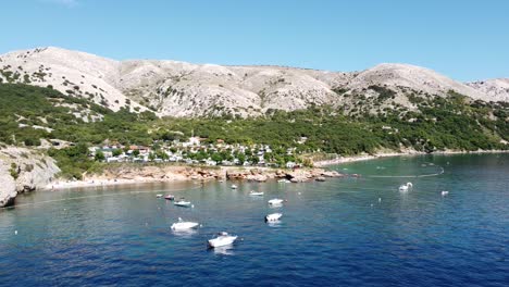 krk island, croatia - aerial drone view of the coast of oprna bay with boats, campsite and beaches at the adriatic sea