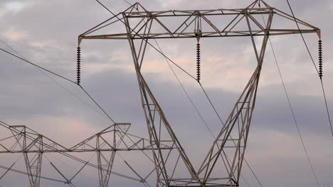 electrical towers against grey clouds