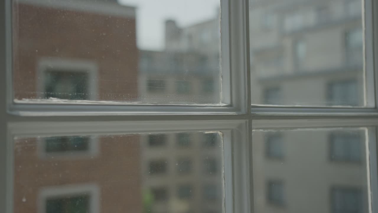 A 5K shot of London buildings through a window frame.