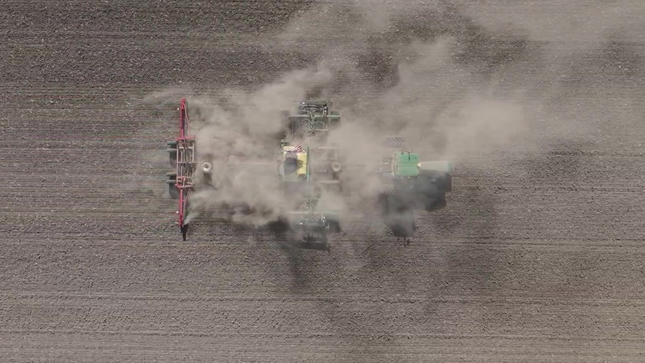 Um agricultor ara um campo agrícola preparando o leito de sementes para a cultura que será plantada