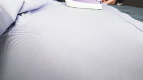 vista de ángulo bajo hombre plancha camisa azul en la tabla de planchar video