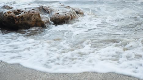 Wellen-Krachen-Am-Späten-Abend-An-Einem-Sandstrand-In-Indien-Gegen-Einen-Felsen-Am-Strand