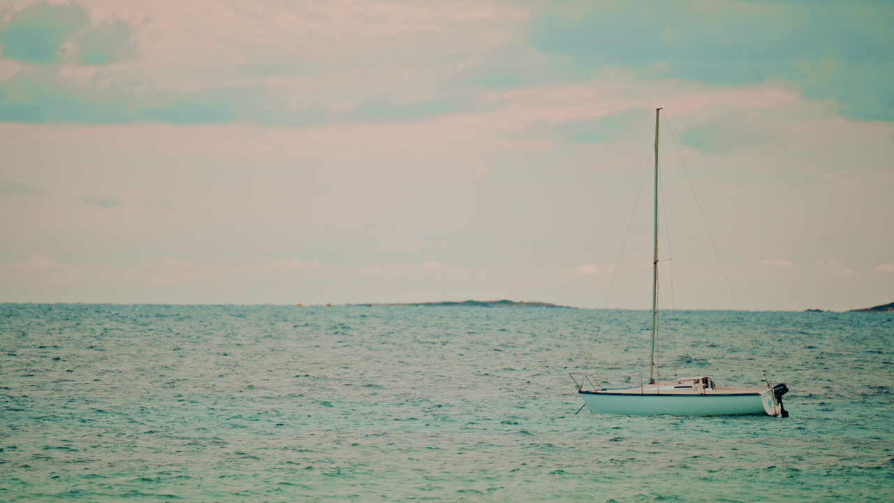 A sailboat steering wheel in warm low sun, with glowing bokeh of other boats in the background, capturing the romance of sailing and yachting