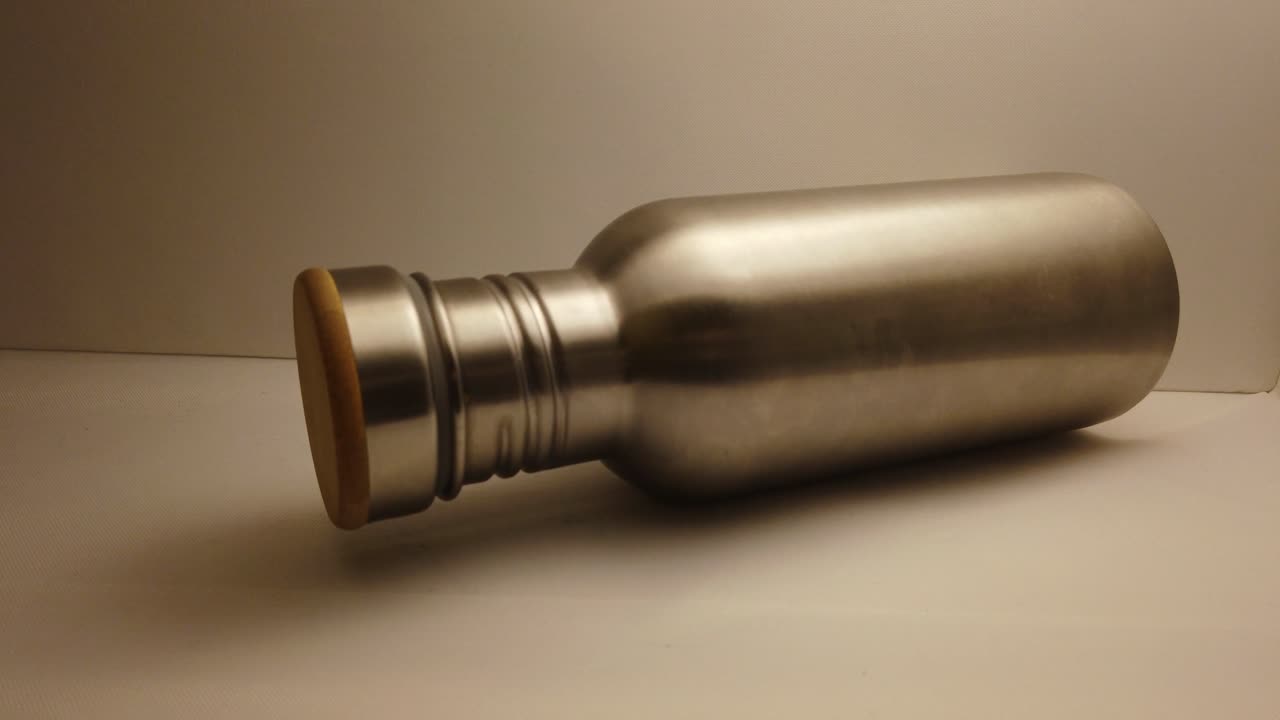 botella de agua de metal tirada en el estante