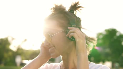 cerca de una chica de cabello claro bailando al ritmo de la música con auriculares. vista frontal de una mujer feliz sacudiendo la cabeza en