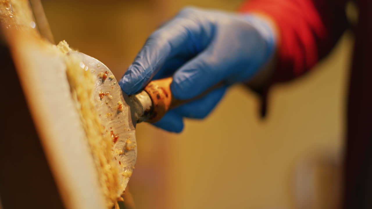 The Beekeeper Removes Wax with a Spatula
