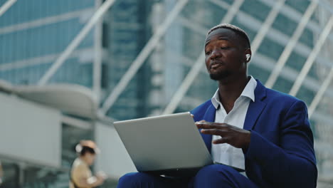 professional black businessman working on laptop outdoors