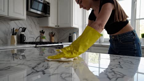 woman cleaning a marble kitchen countertop