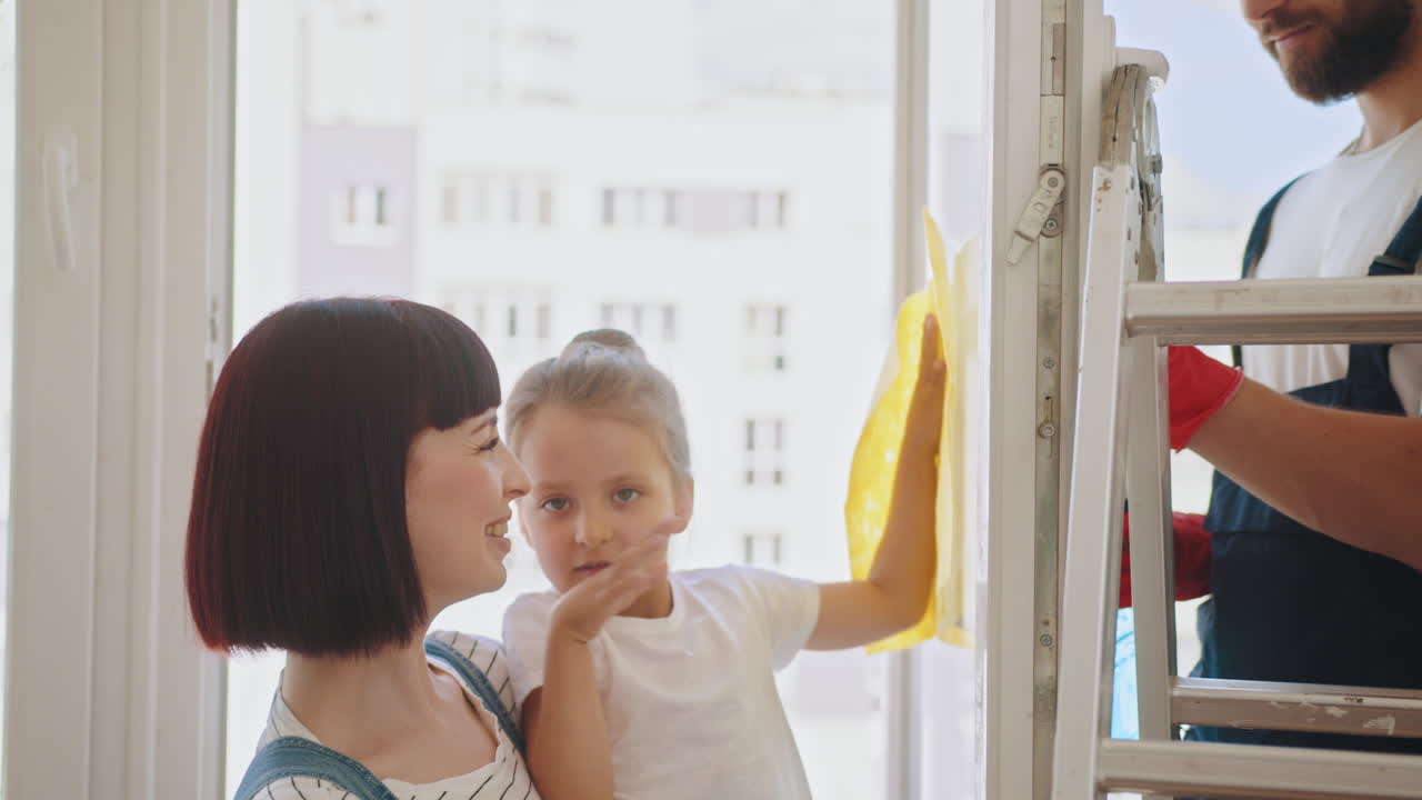 familia limpiando ventanas juntos