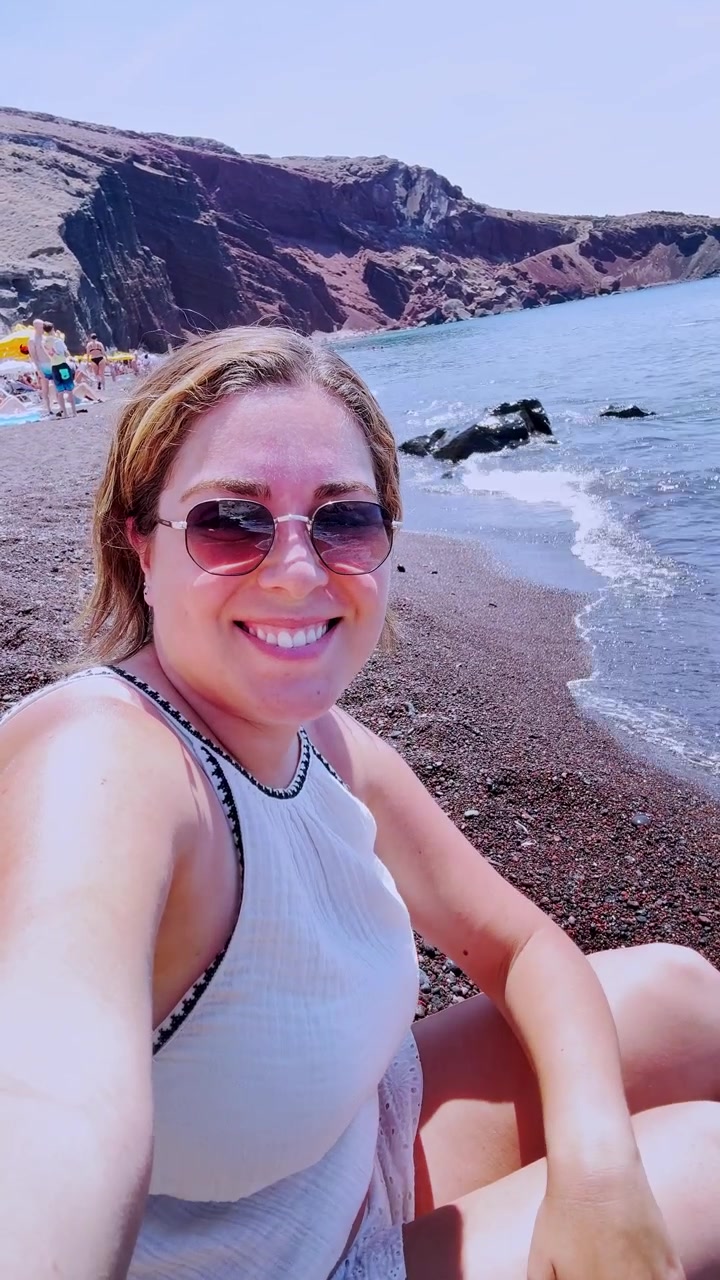 Naisvloggaaja ottaa selfien Punaisella rannalla Santorinissa, Kreikassa