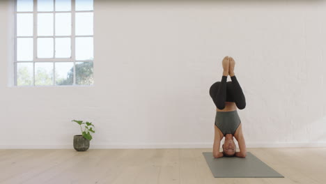 Mujer-De-Yoga-Saludable-Practicando-Pose-De-Cabeza-Disfrutando-De-Un-Estilo-De-Vida-Fitness-Haciendo-Ejercicio-En-El-Estudio-Estirando-Un-Hermoso-Entrenamiento-Corporal-En-Una-Colchoneta-De-Ejercicios