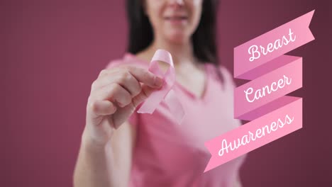 Breast-cancer-awareness-text-banner-against-mid-section-of-woman-holding-a-pink-ribbon