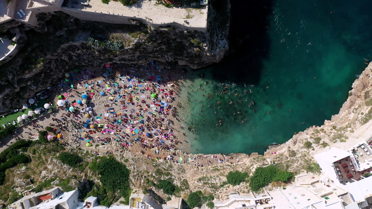 Vista aérea movimentada da praia Lama Monachile em um dia ensolarado na Puglia, Itália