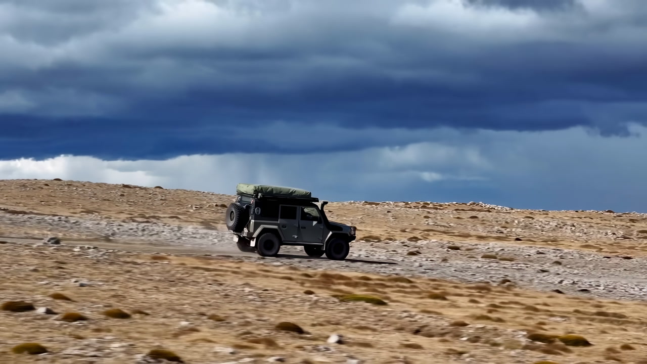 Jeep Crossing Arid Plateau Under Stormy Sky. Lone Expedition Vehicle With Roof Rack Kicking Dust Across Rugged