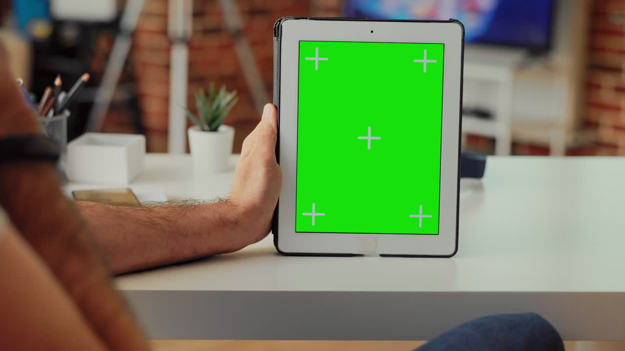 Office employee holding digital gadget showing greenscreen