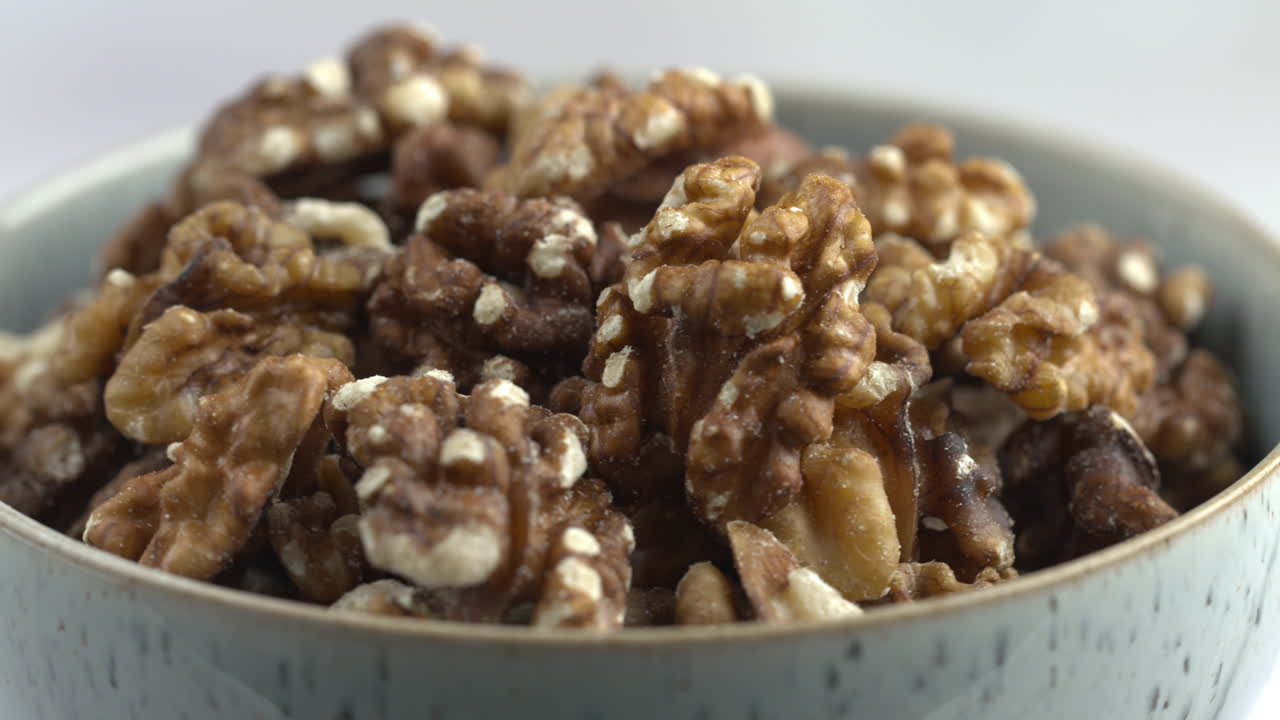 Cuenco giratorio de nueces. Nueces girando. Alimento vegano crudo a base de plantas con proteínas. Alimentos saludables y vegetarianos. Ingredientes para un desayuno saludable. Toma macro 4K