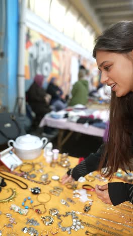 mujer mirando joyas en un mercado callejero