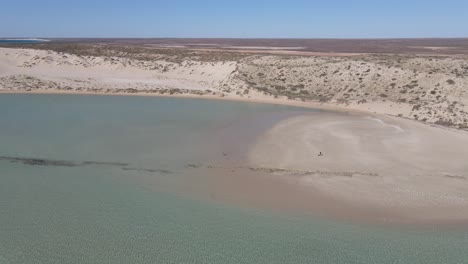 4K-Distant-couple-deserted-beach-aerial-shot-60fps-slow-motion