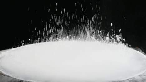 jumping flour on moving subwoofer on black background