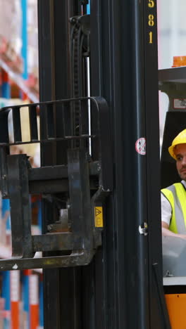 male warehouse worker using forklift truck