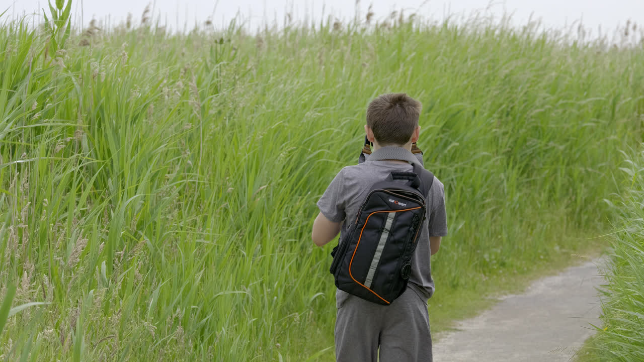 야생동물 영상 제작 을 위해 삼각대를 설치 하는 젊은 사진작가