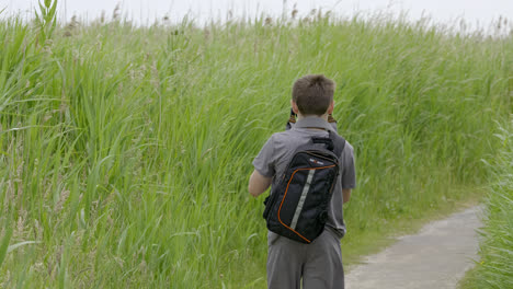 young photographer setting up his tripod for wildlife video production