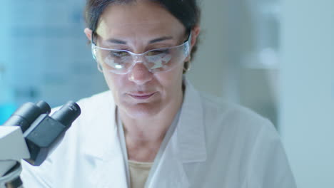 científico mirando a través de un microscopio