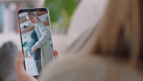 Mujer-Joven-Teniendo-Video-Chat-Usando-Un-Teléfono-Inteligente-En-Casa-Charlando-Con-Una-Amiga-Embarazada-Mostrando-El-Vientre-Compartiendo-El-Embarazo-Charlando-En-Línea-En-La-Pantalla-Vertical-Del-Teléfono-Móvil-4k