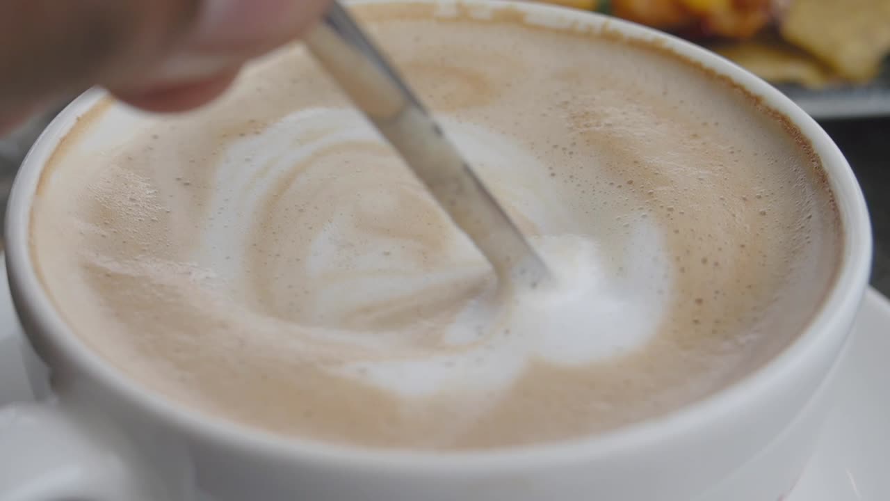 Close-up of a coffee cup with latte art and a spoon