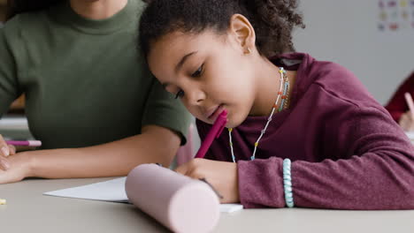 girl student doing homework with teacher
