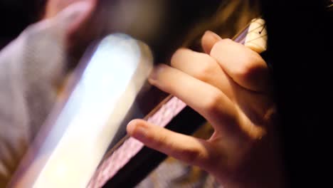 primer plano de manos tocando una guitarra acústica