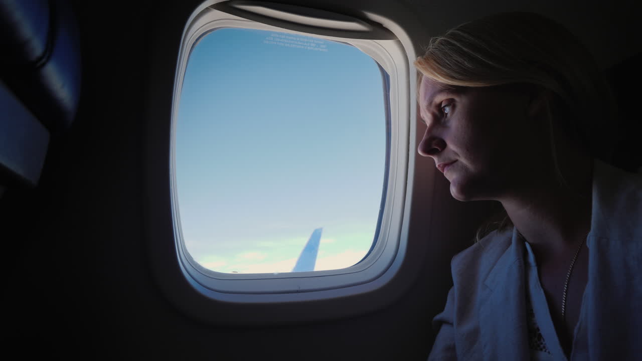 mujer solitaria y triste mira por el ojo de buey del avión