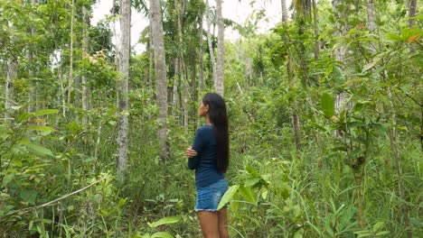 mujer solitaria en medio de un denso bosque tropical