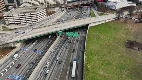 drone tilt up shot of crowded road in atlanta city with crossing bridge in downtown