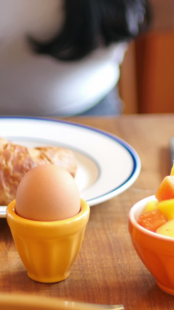 아침 식사를 하는 동안 휴대 전화 를 사용하는 여자