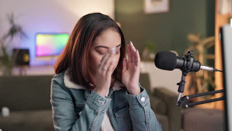 woman with headache recording podcast